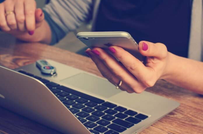 Donna con smartphone e Mac